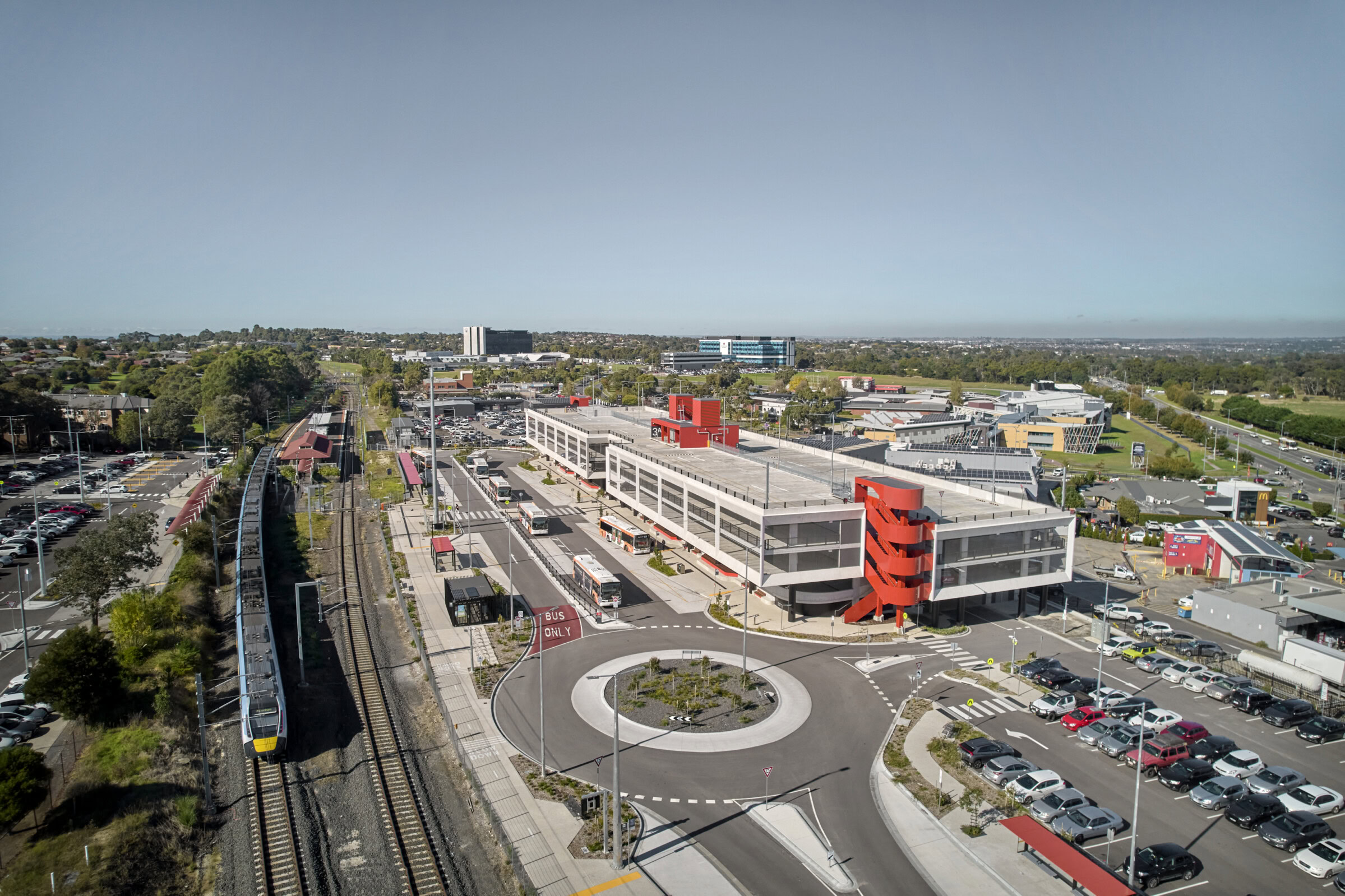Aerial view of integrated transport interchange with train station, bus interchange and multi level car park designed by Genton, showcasing aviation and transport interchange expertise